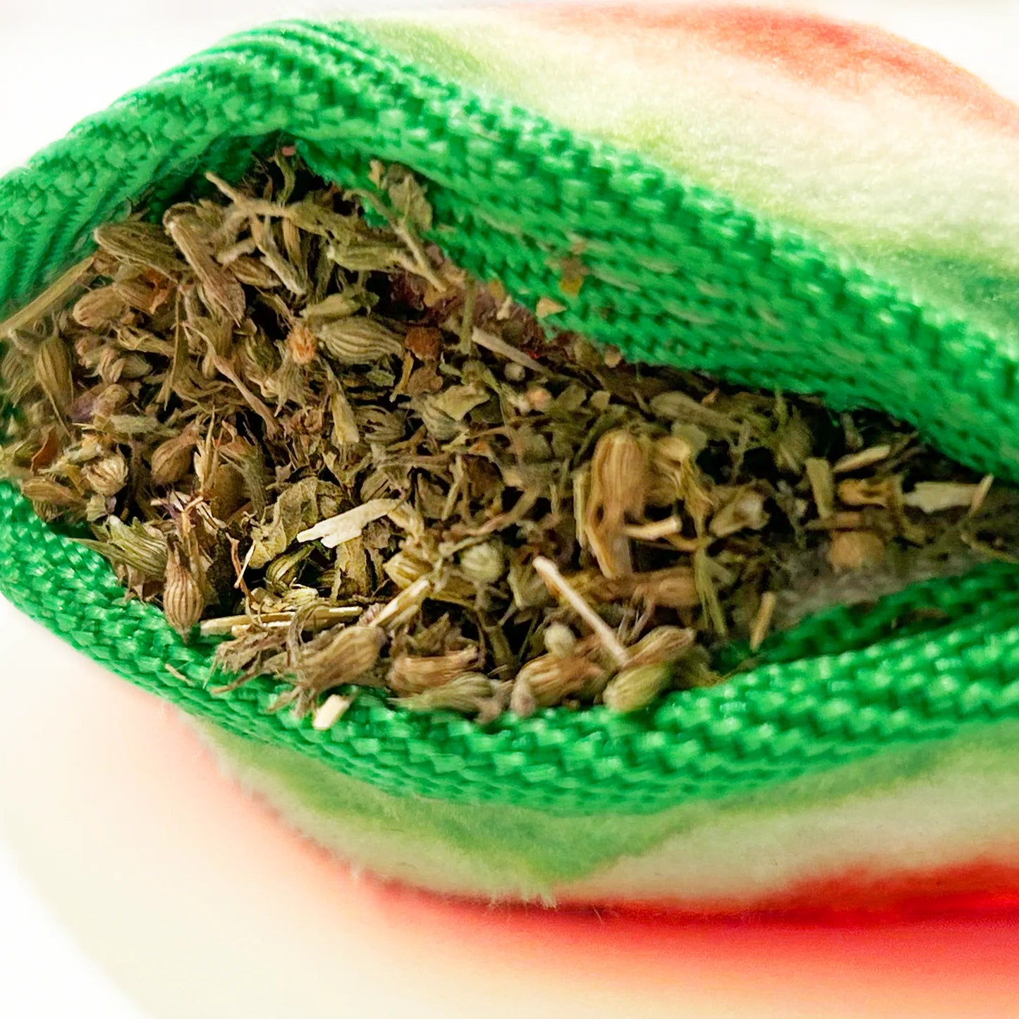 Close-up of Juananip stuffing inside the Watermelon Slice dog toy, showing premium organic calming blend in refillable pocket.